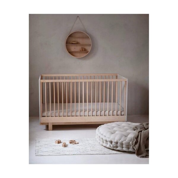 Baby room with baby cot and natural linen sheets
