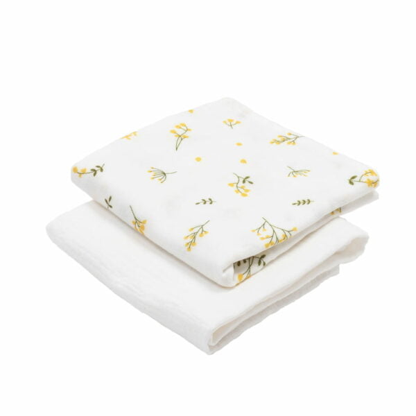 two folded muslin cloths, one with a green and yellow floral motif and the second in white