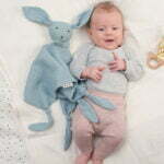 Ein Baby mit Schmusetuch Kuscheltier Häschen mit langen Ohren und vier Tuchecken in Farbe blau aus Bio Musselin