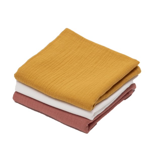 three folded muslin cloths, one all red brown, the second in yellow and the third in white