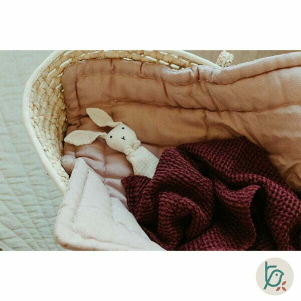 Moses basket with baby horn and A folded Waffle linen blanket in dark cherry