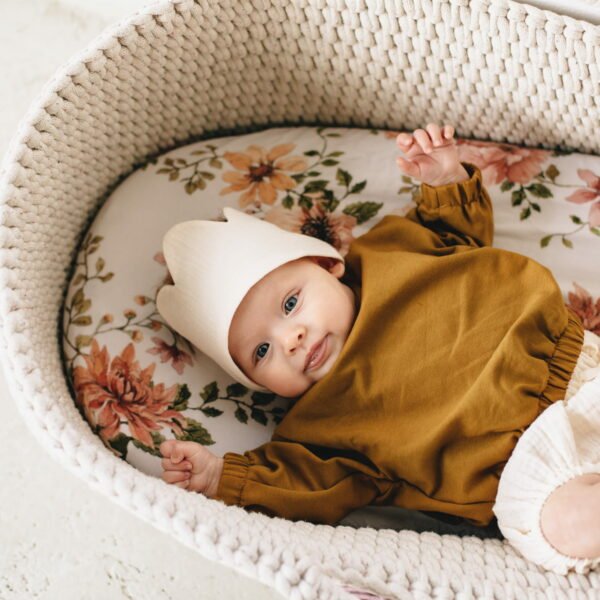 A baby wearing organic cotton sweatshirts with geese embroidery, in caramel colour