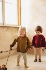 Kleine Kinder gekleidet in einer Bluse mit Gänse Stickerei aus Bio-Baumwolle