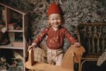 Ein Mädchen im Zimmer gekleidet in Baby Wickelbody aus Bio-Baumwolle mit GOTs Zertifikat und langen Ärmel mit Gänse Muster