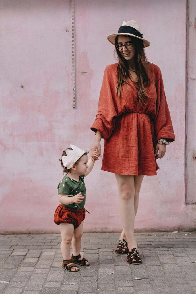 Ein Junge mit Mutter gekleidet in Baby Wickelbody mit Gänse Muster und Bloomers aus Bio-Baumwolle mit GOTs Zertifikat