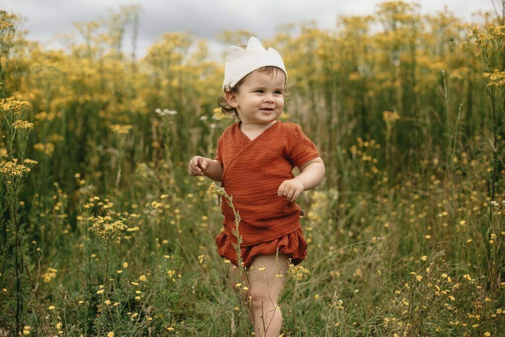a boy wearing a muslin certified wrap shirt and bloomers in red brown colour